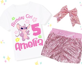 May include: A white t-shirt with a pink cartoon character, the text "Birthday Girl", the number "5", and the name "Amelia". The set includes pink sequin shorts and a matching hair bow. The text "Add an Extra Sparkle with Sequin pants & a Hairbow" is at the top.