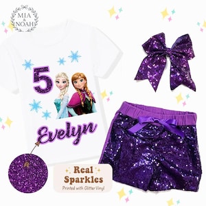 May include: A white t-shirt with a graphic of two animated characters, the number 5, and the name "Evelyn" in purple glitter. The set includes purple sequin shorts and a matching bow. The text "Real Sparkles" is printed on the image.
