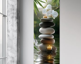 May include: A stack of smooth, grey and brown stones with a lit candle on top, surrounded by water and green bamboo leaves. White orchids are on the top of the stones.
