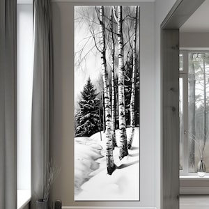 May include: Black and white vertical art print depicting a winter forest scene. Tall birch trees with black and white bark stand in a snowy landscape, with evergreen trees in the background. The artwork is displayed in a modern interior setting.