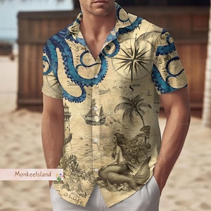 Puede incluir: Una camisa de manga corta con botones con un tema náutico vintage. La camisa presenta un diseño de mapa con un pulpo, una brújula, un barco, una palmera y una sirena. La camisa es beige con detalles azules, marrones y negros.