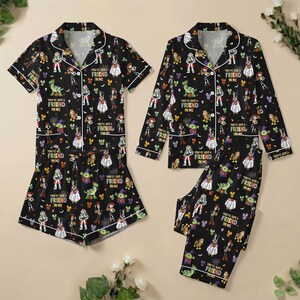 May include: Two sets of black pajamas featuring a repeating pattern of Toy Story characters in Halloween costumes and the text You've Got A Friend In Me. One set includes a short-sleeve button-down shirt and shorts, while the other has a long-sleeve shirt and pants.