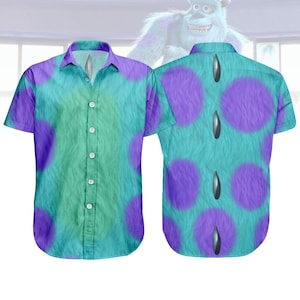 May include: Short-sleeved button-down shirt featuring a teal and purple spotted pattern, reminiscent of a popular animated character. The shirt has a collared neckline and a button-up front. The design includes a teal fur-like texture with large purple spots.