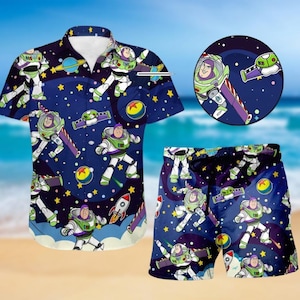 Pode incluir: Um conjunto de camisa e calções azul marinho com um design de personagem de desenho animado. O conjunto inclui uma camisa de manga curta e calções, ambos com um padrão repetido de um personagem de guarda florestal espacial, planetas e estrelas.