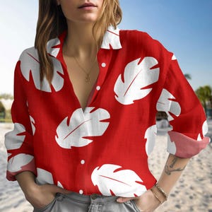 May include: A red long-sleeved button-up shirt with a white leaf pattern.
