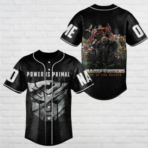 May include: Black baseball jersey with white trim, featuring the text "POWER IS PRIMAL" and a silver Autobot symbol on the front. The back displays a Transformers movie graphic and the number "0".