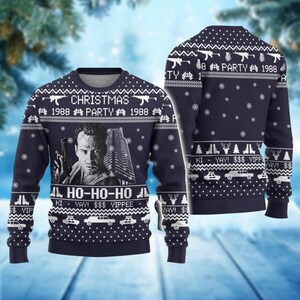 Könnte beinhalten: Marineblauer Weihnachtspullover mit einem Schwarz-Weiß-Bild eines Mannes, der eine Waffe und ein Gebäude hält. Der Pullover hat den Text "CHRISTMAS 1988 PARTY 1988" und "HO-HO-HO" mit Schneeflocken, Waffen, Autos und anderen festlichen Designs.