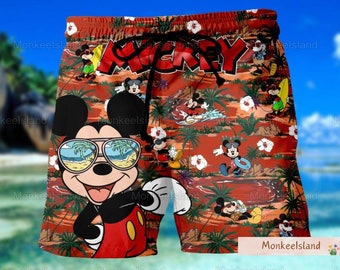 Könnte beinhalten: Rote und grüne gemusterte Badehose mit einem großen Mickey Mouse-Motiv. Mickey Mouse trägt eine Sonnenbrille und hat ein breites Lächeln. Der Text "Mickey" ist auf dem Bund aufgedruckt.