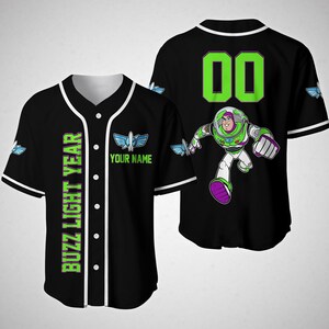 May include: Black baseball jersey with green and white accents. The front of the jersey has the text "Buzz Light Year" and "Your Name" with a space shuttle graphic. The back of the jersey has the number "00" and a cartoon image of Buzz Lightyear from the Toy Story film.