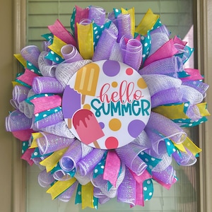 May include: A purple, white, pink, and yellow wreath with a round sign that says "hello summer" and has ice cream cones on it.