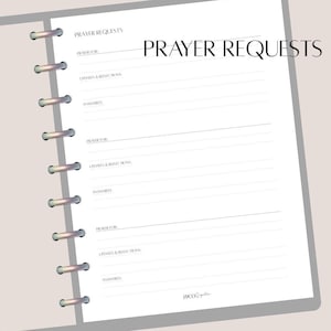 Peut inclure: Une page de planificateur blanche avec le texte "PRAYER REQUESTS" en haut. La page est divisée en sections pour enregistrer les demandes de prière, les mises à jour et les réflexions. Le planificateur est relié par des anneaux argentés.