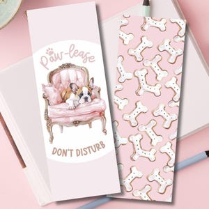 May include: Two decorative bookmarks. One features a French bulldog in a pink chair with the text "Paw-lease" and "Don't Disturb". The other has a pink background with white bone shapes.