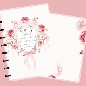 May include: A pink and white notebook with a floral design. The cover features a bouquet of pink and red roses, with a ribbon and the text "SHE IS clothed with strength and dignity: she can laugh at the days to come. PROVERBS 31:25."