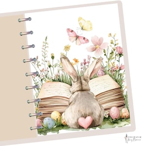 May include: A watercolor illustration of a brown rabbit sitting on an open book with a pink heart on its back. The book is surrounded by green grass, pink and yellow flowers, and colorful Easter eggs.