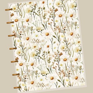 Peut inclure: Une page de planificateur avec un motif floral à l'aquarelle. Le motif présente des marguerites blanches avec des centres jaunes, entrecoupées de feuillage vert et brun, sur un fond crème. La page du planificateur a des anneaux dorés pour la reliure.