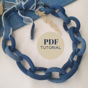 Könnte beinhalten: Eine handgefertigte Jeans-Kettenhalskette mit einem einzigartigen, klobigen Gliederdesign. Die Halskette besteht aus recyceltem blauem Jeansstoff und hat einen Krawattenverschluss. Der Text "PDF TUTORIAL" ist ebenfalls zu sehen.