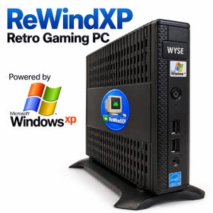 May include: A black Wyse compact desktop computer labeled ReWindXP Retro Gaming PC. The front panel features a Windows XP logo, a power button, two USB ports, and an audio jack. A circular ReWindXP sticker with a computer icon is on the side.