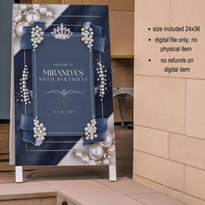 Puede incluir: Un letrero decorativo azul marino y blanco para una celebraci&oacute;n de 50 cumplea&ntilde;os. El letrero presenta el texto "WELCOME TO MIRANDA'S 50TH BIRTHDAY" y la fecha "07.25.20XX". Decorado con perlas, lazos y una corona.