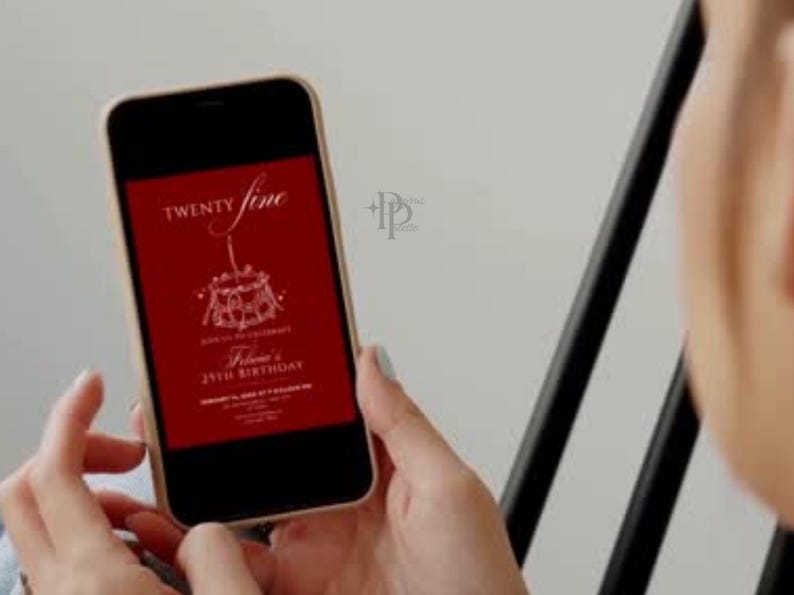May include: A smartphone displays a red birthday invitation with white text. The invitation reads "Twenty Fine" above a cake illustration and "Felina's 25th Birthday" below. The phone is held in front of a light background.