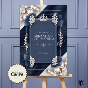 Puede incluir: Un letrero de bienvenida de cumplea&ntilde;os azul marino y blanco con el texto "Bienvenida al 50 cumplea&ntilde;os de Miranda". El letrero est&aacute; decorado con perlas, cintas y una corona. El letrero se muestra en un caballete de madera.