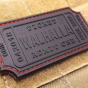 Peut inclure: Patch de billet noir avec des coutures rouges. Le billet indique "ODIN 04/20/18 TICKET VALHALLA ADMIT ONE FREE BEER APPROVED".