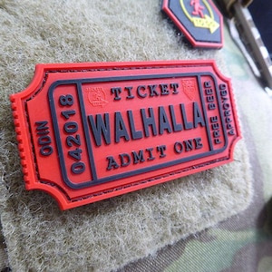 Może przedstawiać: Czerwono-czarna łatka biletu z tekstem "ODIN 04.2018 TICKET WALHALLA ADMIT ONE FREE BEER APPROVED".