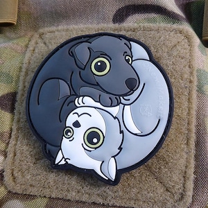Könnte beinhalten: Ein schwarz-weißes Yin-Yang-Design mit einem Cartoon-Hund und einer Katze. Der Hund ist schwarz und die Katze ist weiß. Der Hund befindet sich auf der linken Seite des Designs und die Katze auf der rechten Seite. Der Hund schaut die Katze an und die Katze schaut den Hund an.