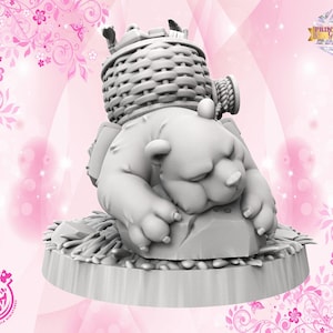 May include: A 3D-printed figurine of a sleeping bear with a woven basket on its back. The bear is resting on a log-like base. The figurine is gray and has a detailed texture. The background is pink with floral and butterfly accents.