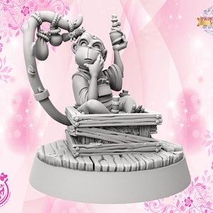 Könnte beinhalten: Graue 3D-gedruckte Miniatur einer affenähnlichen Kreatur, die in einer Holzkiste sitzt und eine Flasche hält. Die Figur steht auf einem runden Sockel mit einer geschwungenen Stütze darüber, die mit Beuteln verziert ist. Logos "Cast n Play" und "Print Shop Girls".