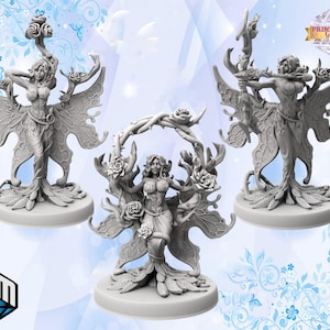 Op de afbeelding: Drie grijze harsfiguren van feeën met vlinder vleugels, elk staand op een ronde basis. De feeën zijn in verschillende poses geposeerd, een houdt een boog en pijl vast, een houdt een bloem vast en een houdt een staf vast. De figuren zijn allemaal gedetailleerd met ingewikkelde ontwerpen en texturen.