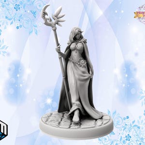 May include: A gray 3D printed miniature of a female figure with pointed ears, wearing a long flowing robe and holding a staff with a crescent moon design. The figure is standing on a circular base.