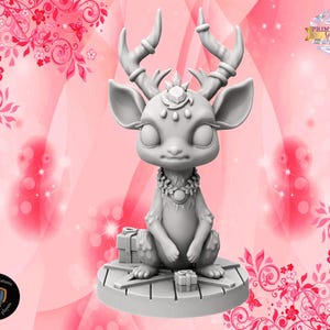 May include: A 3D-printed figurine of a deer-like creature with large ears, antlers, and a jeweled necklace. The figurine is light gray and sits on a round platform with two small gift boxes. The background is pink with floral and butterfly designs.