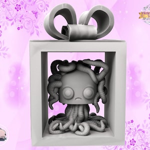 May include: A grey 3D printed figurine of a creature with a large head and many tentacles, inside a white gift box with a grey bow. The box is on a pink background with floral designs.