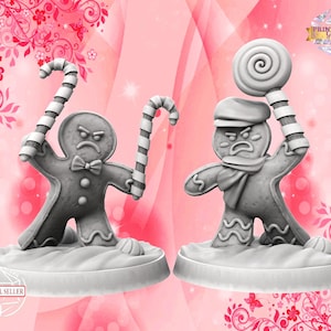 Può includere: Due statuette grigie di omini di pan di zenzero con espressioni arrabbiate. Uno tiene bastoncini di zucchero, l'altro un lecca lecca. Sono su una base bianca, su uno sfondo floreale rosa. Il testo "PRINT SHOP Girls" è visibile.
