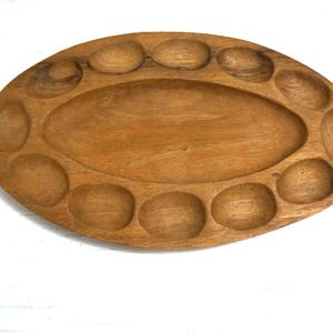 May include: A white ceramic mug with a black handle and the text "But First, Coffee" in a black, bold font. The mug is on a white surface. The mug is approximately 4 inches tall.