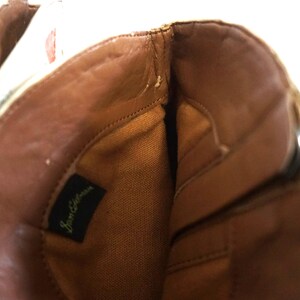 K&ouml;nnte beinhalten: Das Innere eines braunen Lederstiefels mit einem beigefarbenen Stofffutter. Der Stiefel hat einen Rei&szlig;verschluss und ein Etikett mit der Aufschrift "Sam Edelman".