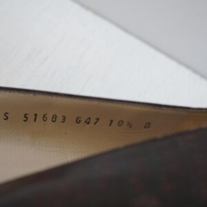 May include: Close-up of the inside of a brown leather shoe with the text "DS 51683 647 10 1/2 B" printed on the insole.