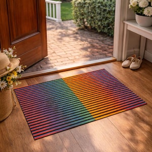 Puede incluir: Una alfombra rectangular con un diseño de rayas en colores arcoíris. La alfombra está dividida en dos secciones, una con rayas azules y verdes, y la otra con rayas naranjas y amarillas. Está colocada sobre un suelo de madera.