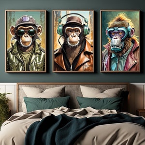 Puede incluir: Tres impresiones artísticas enmarcadas que representan monos antropomórficos con atuendos elegantes. Los monos llevan gafas de sol, auriculares y un respirador. La obra de arte cuelga sobre una cama con ropa de cama neutra, cojines color teal y una manta azul oscuro.