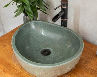May include: A green stone vessel sink with a black drain and a black bamboo style faucet.