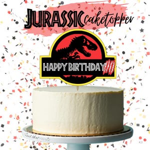Peut inclure: Un gâteau blanc avec un cake topper "Joyeux Anniversaire" avec une silhouette de dinosaure et le texte "Jurassic". Le gâteau est sur un présentoir à gâteau blanc, avec des confettis en arrière-plan.