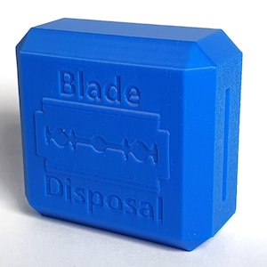 May include: A bright blue blade disposal container. The container has the words "Blade Disposal" embossed on the front, along with an image of a razor blade. The container is a solid, rectangular shape.