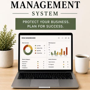 May include: A laptop displaying a risk management dashboard with charts and data. The text reads "SMALL BUSINESS RISK MANAGEMENT SYSTEM" and "PROTECT YOUR BUSINESS. PLAN FOR SUCCESS." A coffee mug and a small plant are on the wooden desk.