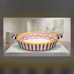 May include: A round ceramic baking dish featuring a yellow rim, a pink wavy line pattern, and a purple and yellow striped exterior. The dish includes two side handles decorated with black and white stripes and small pink accents.