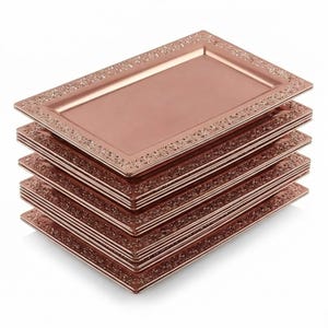 May include: A stack of six rectangular serving trays in a rose gold color. Each tray has a decorative floral border. The trays are stacked on top of each other, with the top tray slightly offset to show the others.