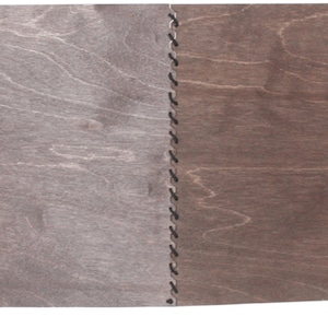 Peut inclure: Un plateau de jeu en bois avec quatre panneaux reliés. Les panneaux sont de couleur marron foncé et sont assemblés par une série de coutures. Trois petits dés bleus sont dans le coin inférieur gauche du plateau.