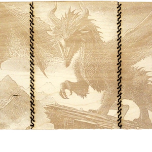 Puede incluir: Una caja de madera con un diseño de dragón grabado en la parte delantera. La caja está dividida en tres secciones y tiene un borde negro cosido. Hay cuatro dados azules delante de la caja.