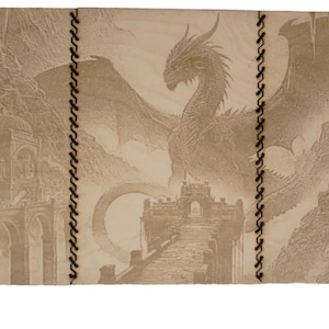 Può includere: Un diario rilegato in pelle beige con un designo di drago e castello. Il diario ha una cucitura sul dorso ed è chiuso.