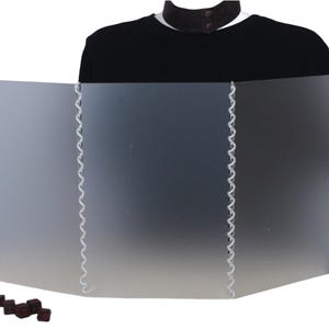 Puede incluir: Una pantalla de acrílico esmerilado de tres paneles con costuras blancas a lo largo de las costuras. La pantalla está de pie sobre una superficie blanca. Hay varios dados negros pequeños en primer plano.