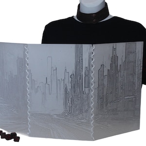 Puede incluir: Una pantalla de juego de mesa de tres paneles de color gris con temática de ciudad, con un borde blanco cosido. La pantalla está plegada y de pie sobre una superficie blanca. Hay seis dados rojo oscuro delante de la pantalla.